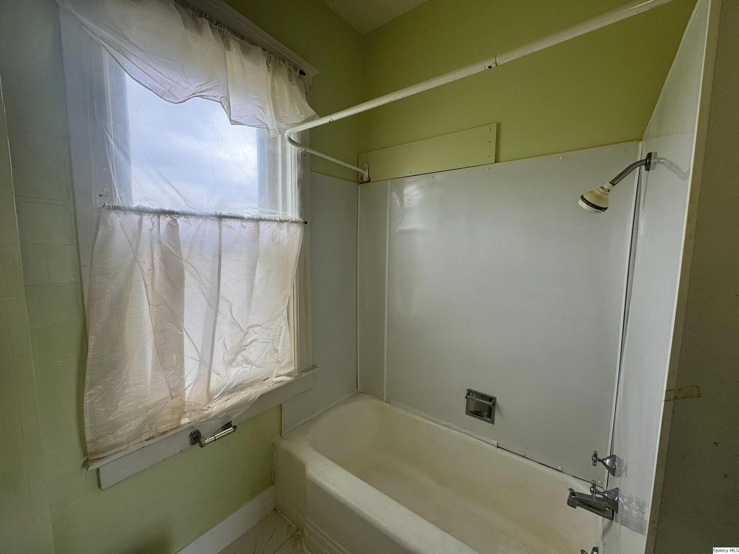608 Adams Street Quincy, IL 62301 - Photo 13 of 19 a bathroom with a bathtub and a shower