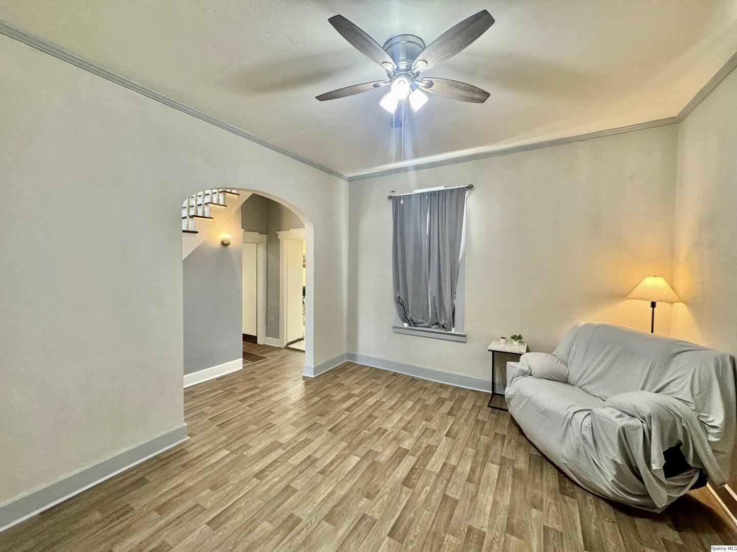 608 Adams Street Quincy, IL 62301 - Photo 3 of 19 a view of a livingroom with a furniture chandelier fan and a hardwood floor