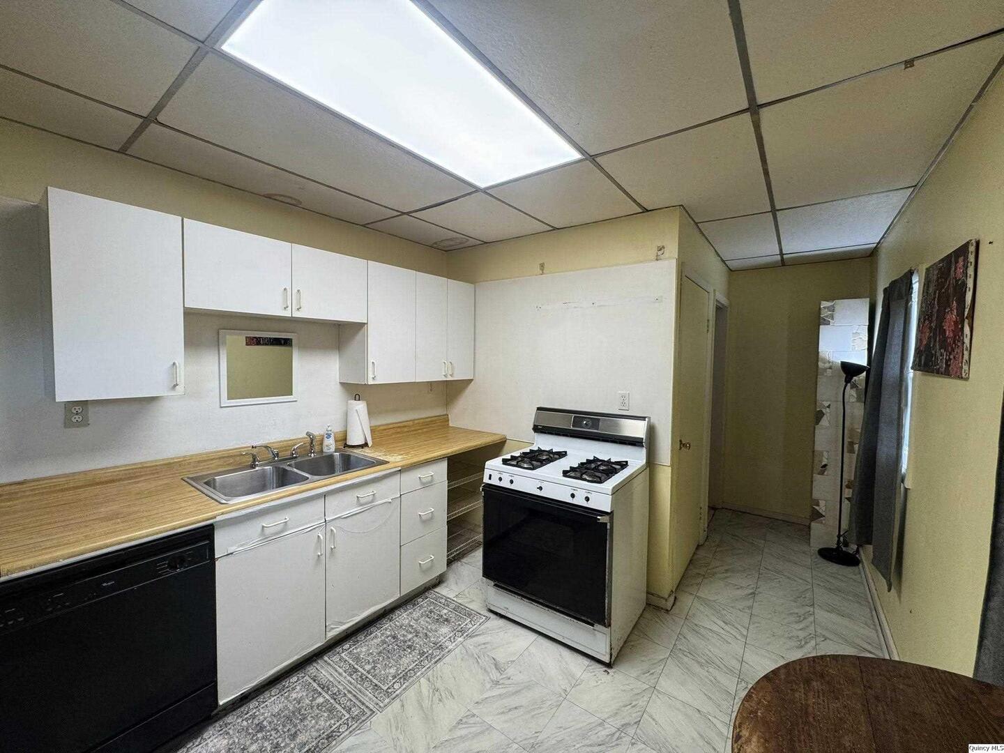 608 Adams Street Quincy, IL 62301 - Photo 5 of 19 a kitchen with stainless steel appliances granite countertop a sink stove and refrigerator