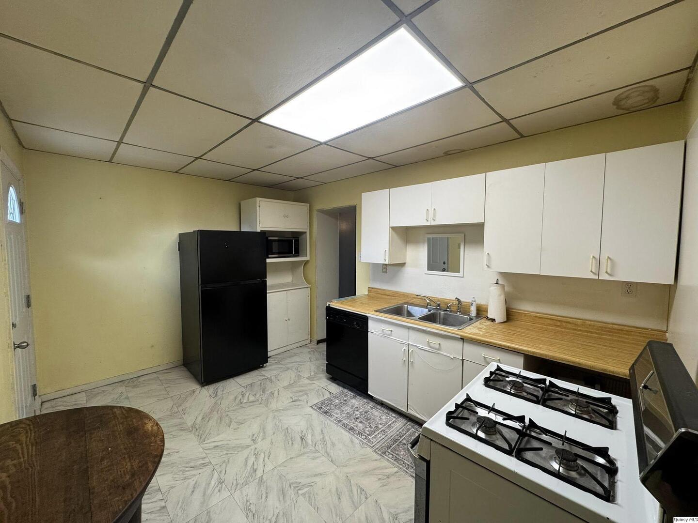 608 Adams Street Quincy, IL 62301 - Photo 6 of 19 a kitchen with stainless steel appliances granite countertop a refrigerator and a stove top oven