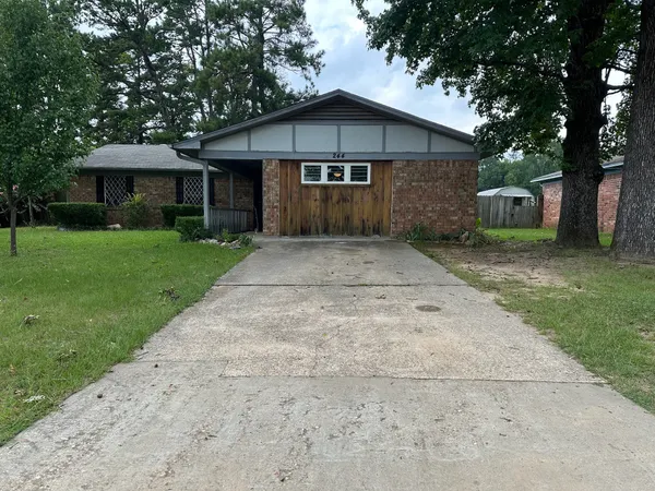 a front view of a house with a yard and trees