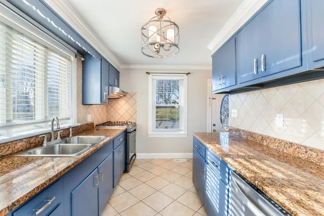 a kitchen with stainless steel appliances granite countertop a sink stove and cabinets