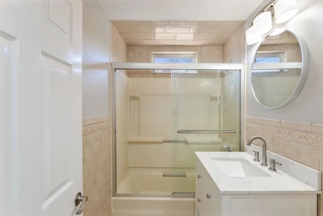 a bathroom with a sink a mirror and a shower