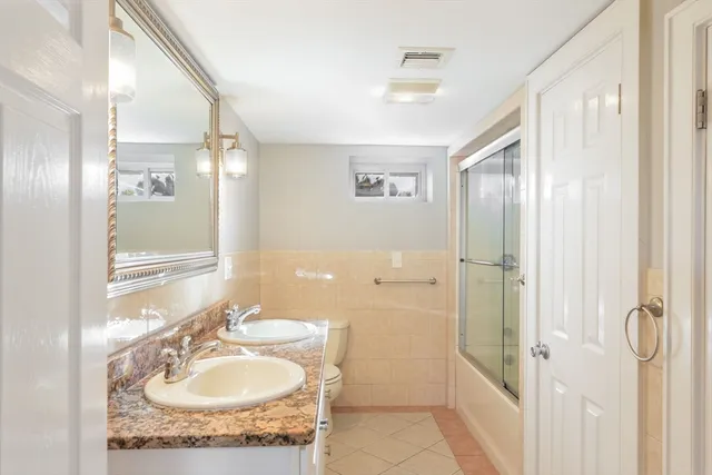 a bathroom with a granite countertop sink a mirror and a shower