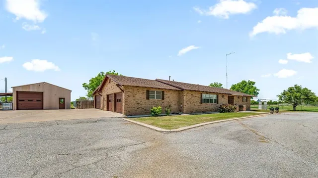 a front view of a house with a big yard and large trees