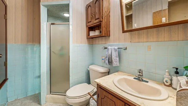a bathroom with a sink a toilet and shower