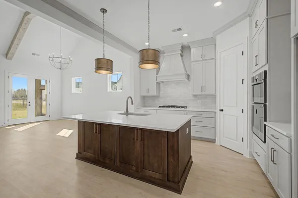 a kitchen with a sink a stove and cabinets