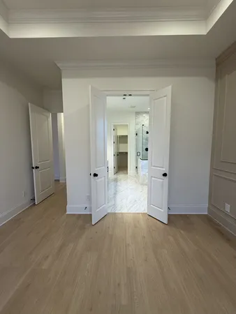 a view of an empty room with wooden floor and windows