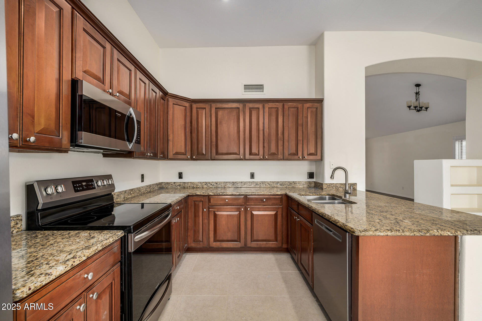 15002 South 47th Street Phoenix, AZ 85044 - Photo 14 of 41 a kitchen with stainless steel appliances granite countertop a stove a sink dishwasher and a microwave oven with wooden cabinets