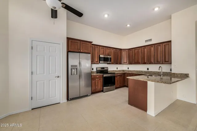 a kitchen with stainless steel appliances granite countertop a refrigerator and a sink