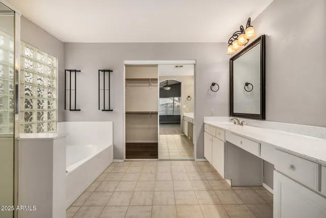 a large white kitchen with a sink and refrigerator