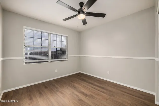 an empty room with a window and a ceiling fan