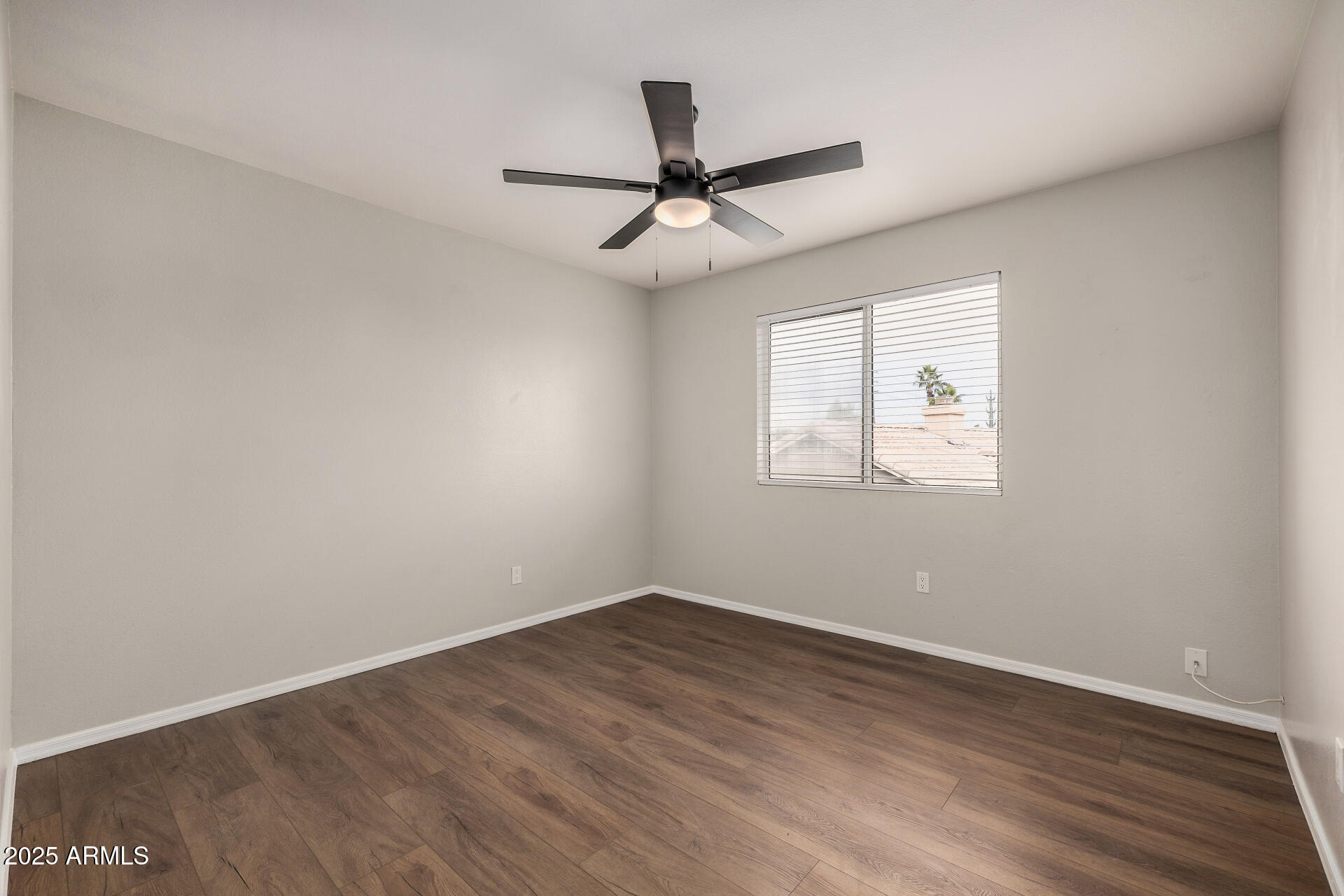 15002 South 47th Street Phoenix, AZ 85044 - Photo 30 of 41 an empty room with wooden floor ceiling fan and windows
