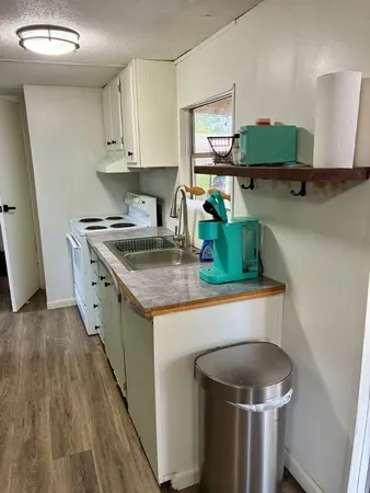 a kitchen with a sink a stove and cabinets