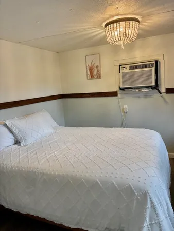 a bedroom with a bed and a painting on the wall