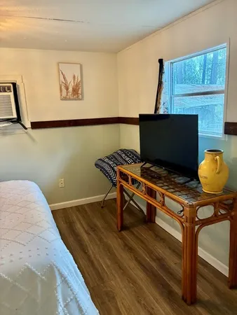 a bedroom with a bed and flat screen tv