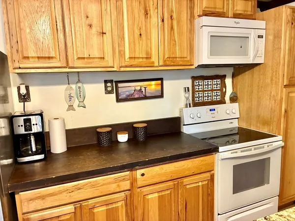 a kitchen with stainless steel appliances granite countertop a sink a stove and white cabinets