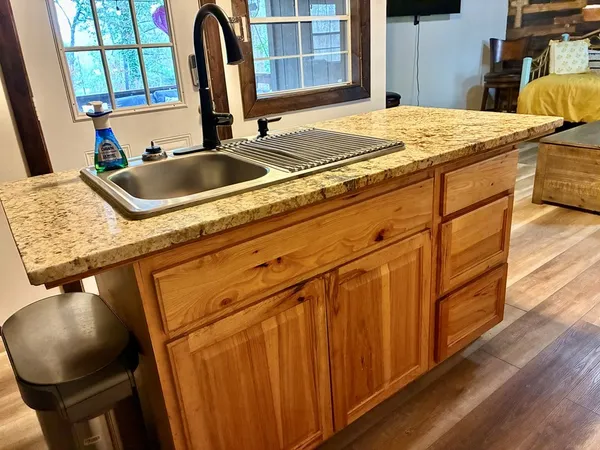 a kitchen with a sink and a wooden floor