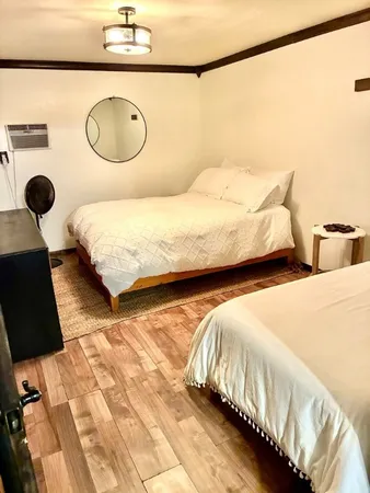 a bedroom with two bed and painting on the wall