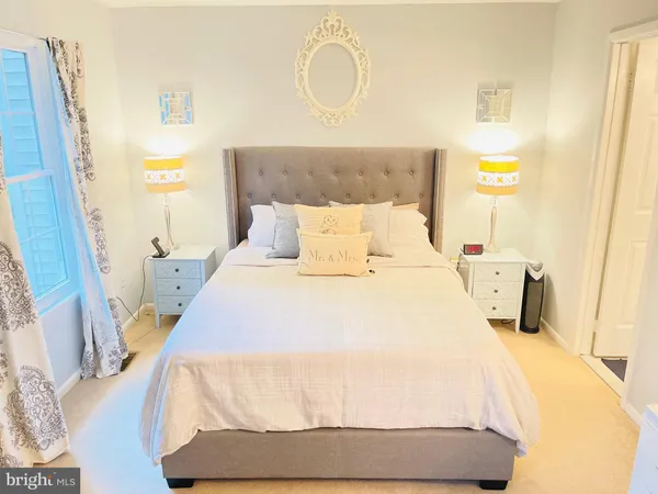 a bedroom with a bed and painting on the wall