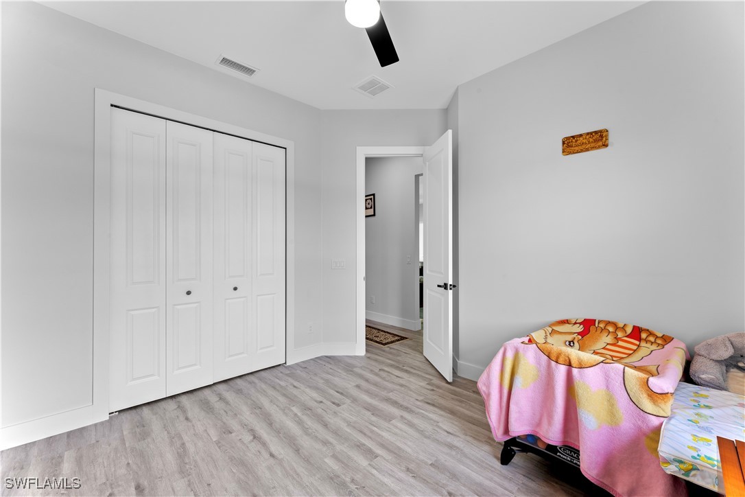 3002 42nd Street Southwest Lehigh Acres, FL 33976 - Photo 11 of 25 a bedroom with a bed and a lamp