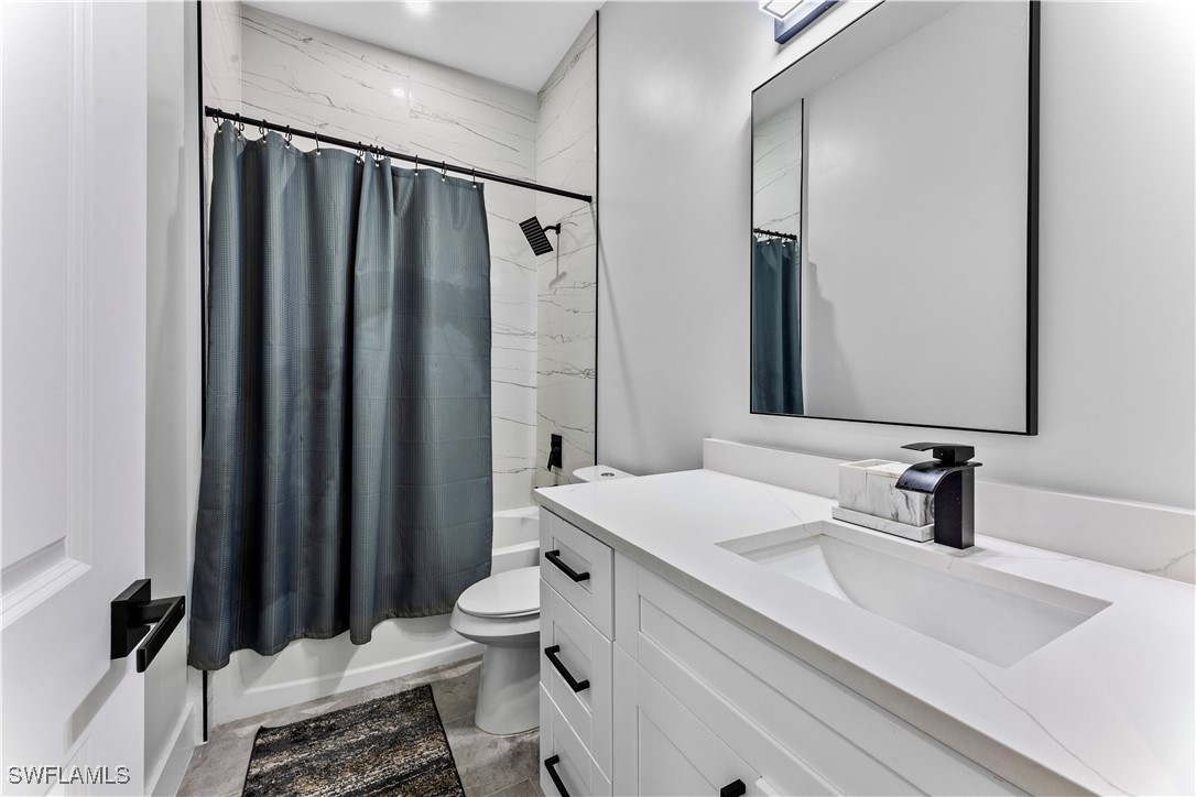 3002 42nd Street Southwest Lehigh Acres, FL 33976 - Photo 12 of 25 a bathroom with a double vanity sink mirror and toilet
