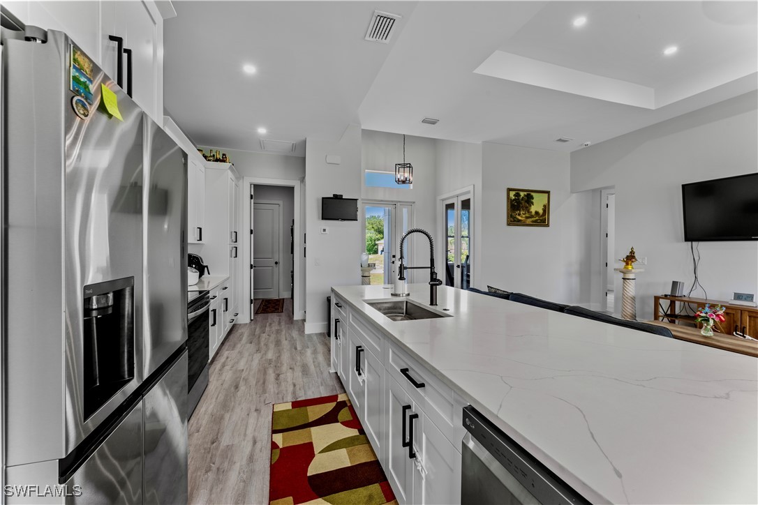 3002 42nd Street Southwest Lehigh Acres, FL 33976 - Photo 16 of 25 a kitchen with stainless steel appliances a sink stove and refrigerator