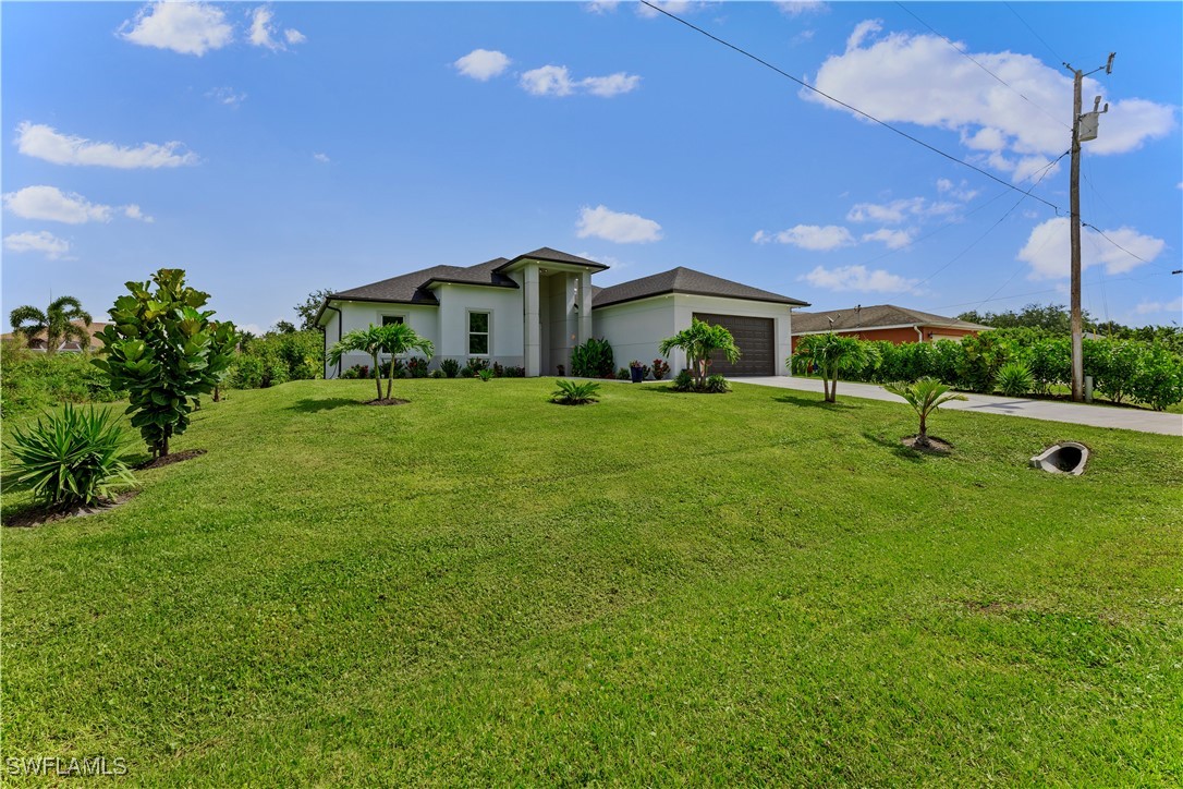 3002 42nd Street Southwest Lehigh Acres, FL 33976 - Photo 2 of 25 a front view of a house with a yard