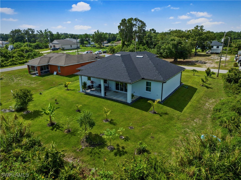 3002 42nd Street Southwest Lehigh Acres, FL 33976 - Photo 21 of 25 a aerial view of a house with swimming pool and green space