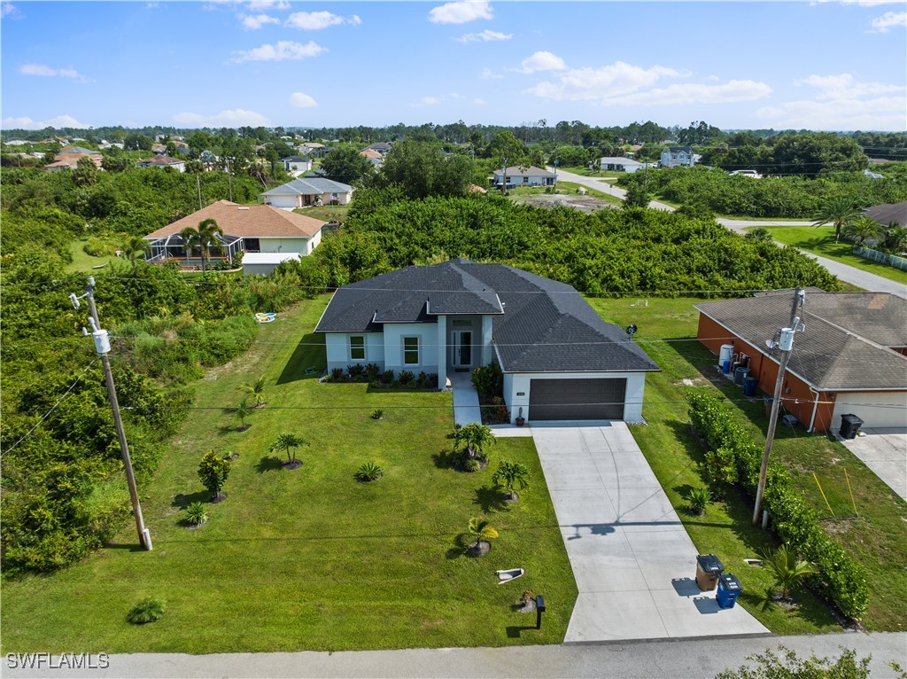 3002 42nd Street Southwest Lehigh Acres, FL 33976 - Photo 23 of 25 an aerial view of multiple houses with yard