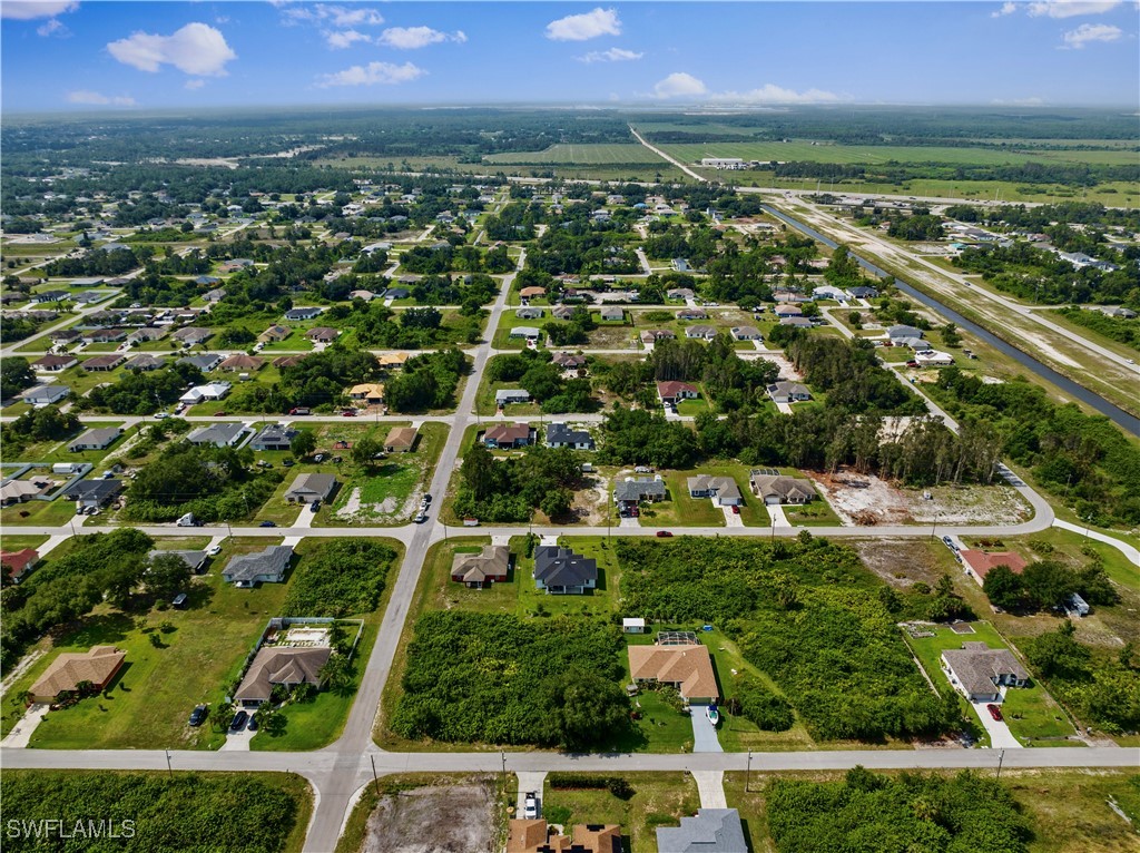 3002 42nd Street Southwest Lehigh Acres, FL 33976 - Photo 25 of 25 an aerial view of residential houses with outdoor space and trees