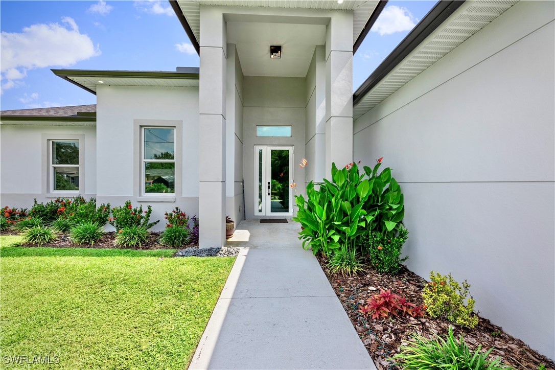 3002 42nd Street Southwest Lehigh Acres, FL 33976 - Photo 3 of 25 a view of a house with a flower garden