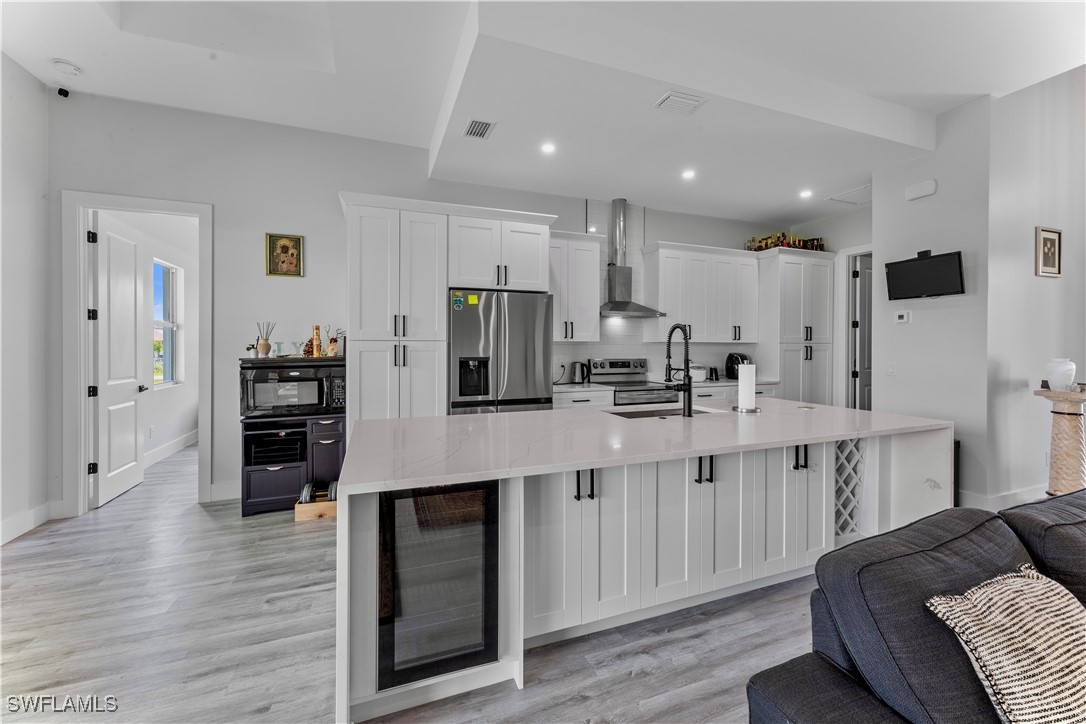 3002 42nd Street Southwest Lehigh Acres, FL 33976 - Photo 5 of 25 a kitchen with stainless steel appliances kitchen island granite countertop a refrigerator and cabinets