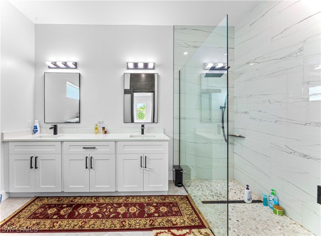 3002 42nd Street Southwest Lehigh Acres, FL 33976 - Photo 7 of 25 a bathroom with a double vanity sink and a mirror