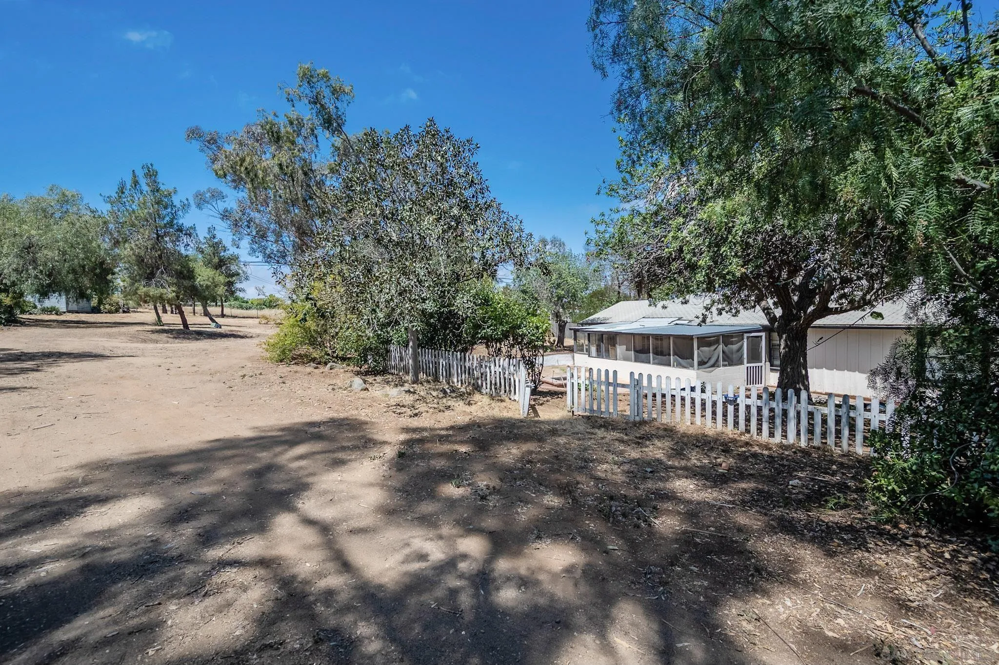 1367 Green Canyon Road Fallbrook, CA 92028 - Photo 39 of 42 a view of a house with a small yard and a large tree