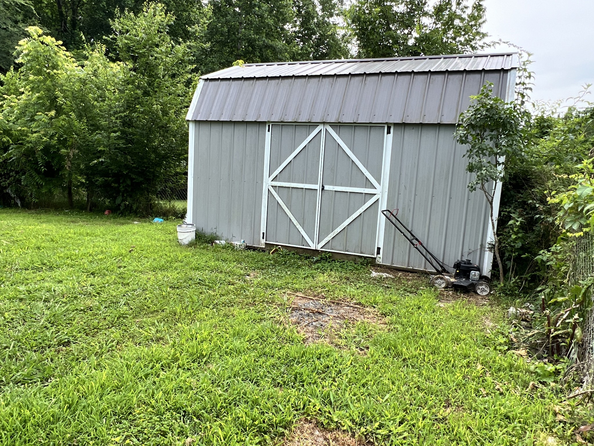 10338 Chappell Cemetery Road Bon Aqua, TN 37025 - Photo 5 of 21 a view of a backyard with potted plants and wooden fence