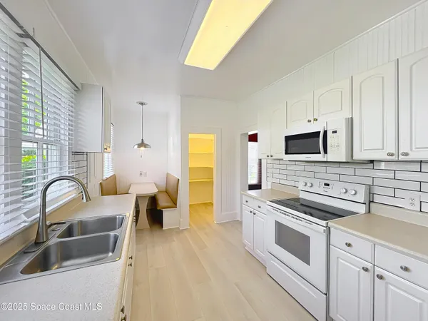 a kitchen with stainless steel appliances a stove a sink a microwave and cabinets