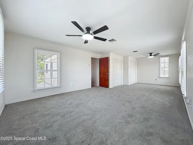 a view of a livingroom with a ceiling fan and window