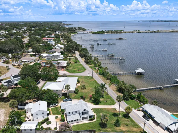 an aerial view of a house with a garden and lake view