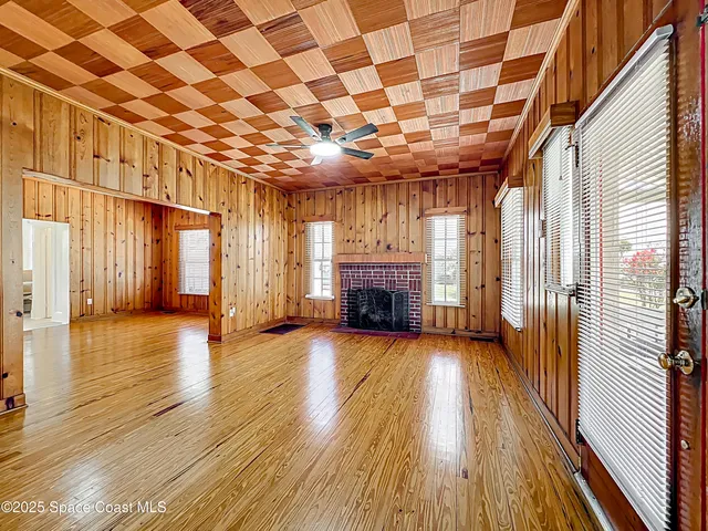 a view of empty room with wooden floor and fireplace