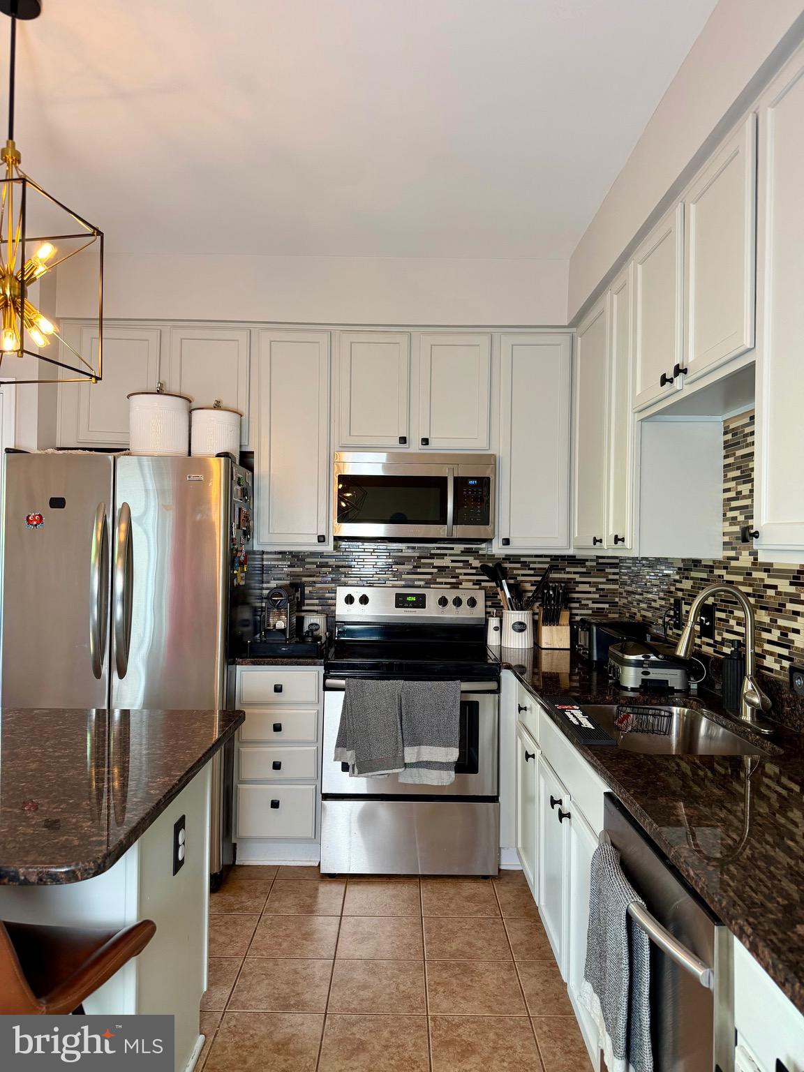 7108 Wheeling Way Gainesville, VA 20155 - Photo 12 of 45 a kitchen with stainless steel appliances granite countertop a stove a refrigerator and a sink