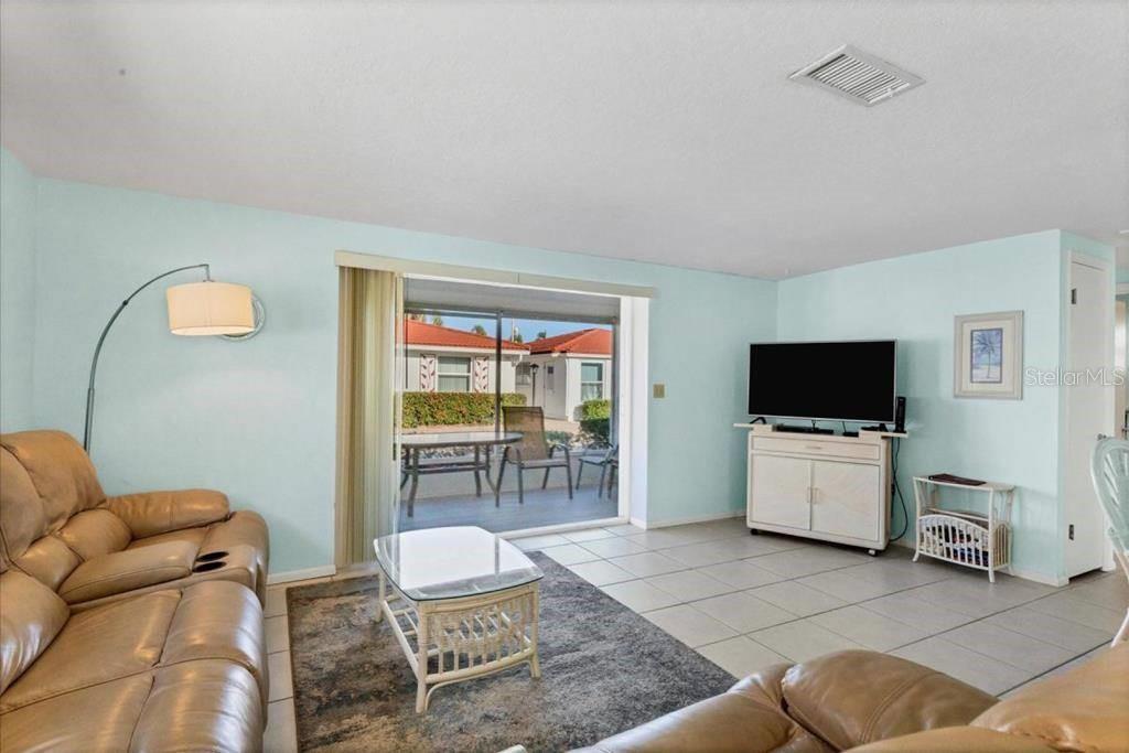6154 Midnight Pass Road, Unit D06 Sarasota, FL 34242 - Photo 2 of 10 a living room with furniture and a flat screen tv