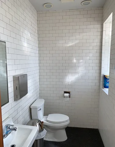 a bathroom with a toilet sink and mirror
