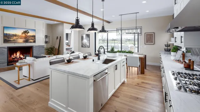 a room with stainless steel appliances kitchen island granite countertop a sink and wooden cabinets