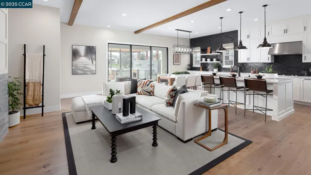 a living room with furniture white walls and a view of kitchen