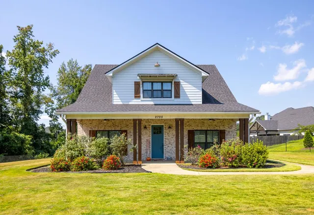 a front view of a house with a yard and swimming pool
