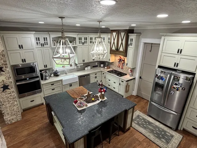 a kitchen with granite countertop stainless steel appliances a sink stove and refrigerator