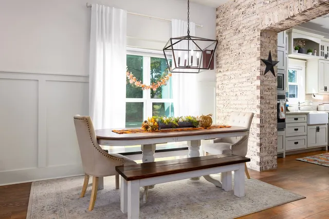 a living room with table chairs and wooden floor