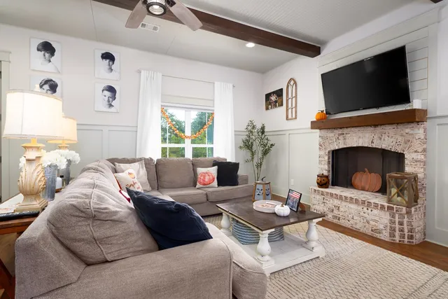 a living room with furniture a flat screen tv and a fireplace
