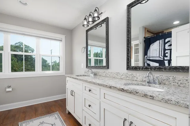 a bathroom with double vanity sink and a window